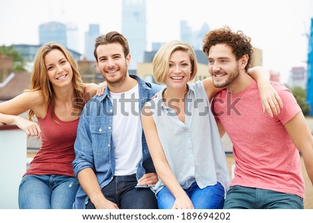 Group Of Friends Relaxing Together On Rooftop Terrace
