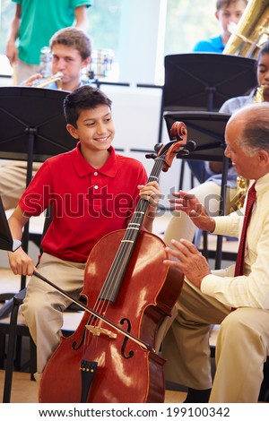 Boy Learning To Play Cello In High School Orchestra