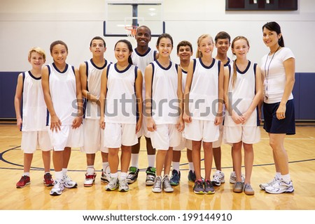 Portrait Of High School Sports Team In Gym With Coach