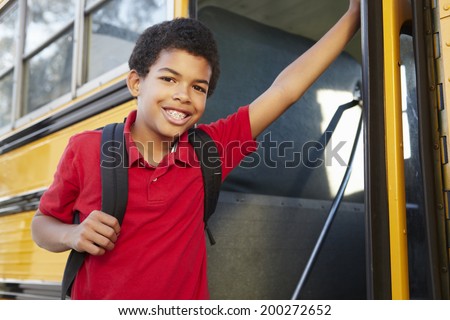 Pre teen boy getting on school bus