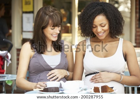 Pregnant women sitting outside cafe