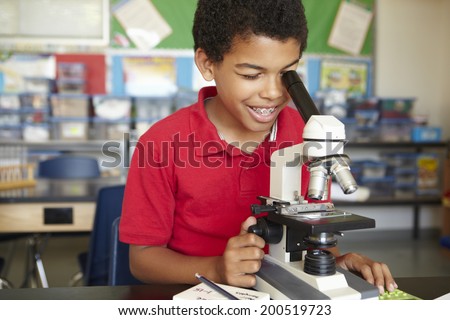 Boy in science class with microscope
