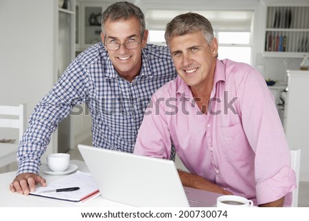 Mid age men working on laptop at home