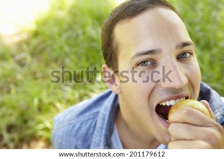 Man eating apple outdoors