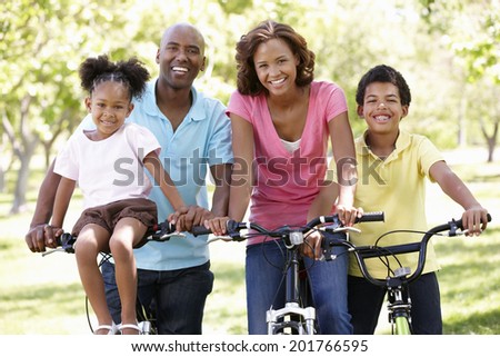 Family cycling in park