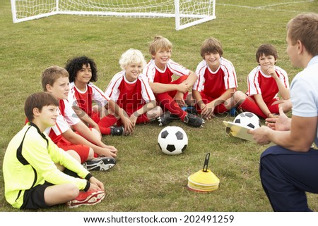 Junior football team training with coach