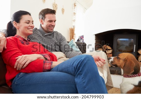 Couple Relaxing At Home With Pet Dog