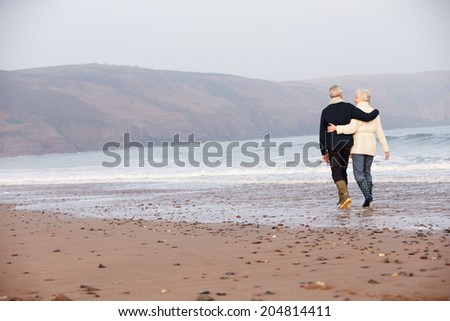 Senior Couple Walking Along Winter Beach