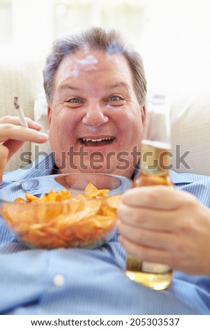 Overweight Man Eating Chips, Drinking Beer And Smoking