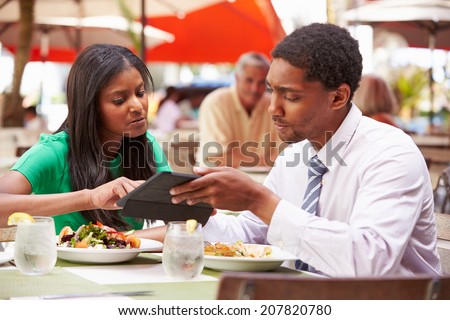 Two Businesspeople Having Meeting In Outdoor Restaurant