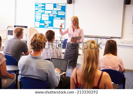 Teacher With College Students Giving Lesson In Classroom