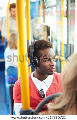 Man Wearing Headphones Listening To Music On Bus Journey