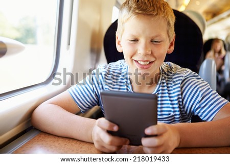 Boy Reading E Book On Train Journey