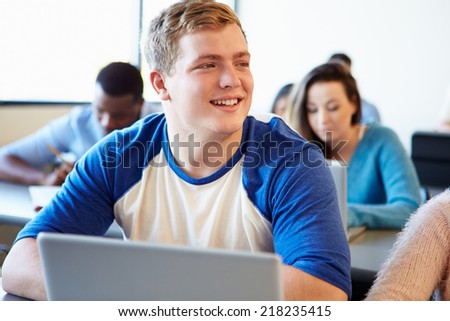 Male University Student Using Laptop In Classroom