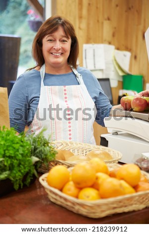 Female Sales Assistant At Checkout Of Farm Shop