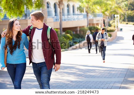Student Couple Walking Outdoors On University Campus