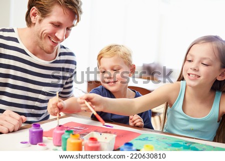 Father Painting Picture With Children At Home