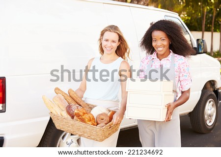 Female Bakers Unloading Bread And Cakes From Van