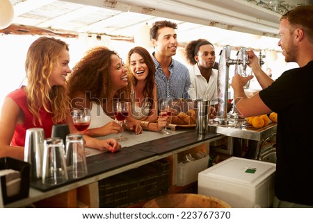 Group Of Friends Enjoying Drink At Outdoor Bar