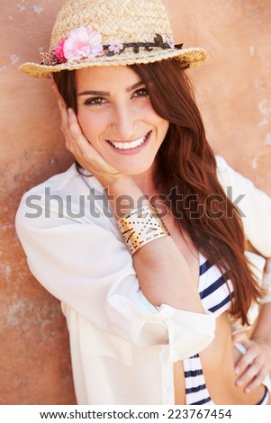 Head And Shoulders Portrait Of Pretty Woman Against Wall