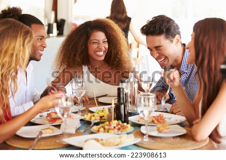 Group Of Young Friends Enjoying Meal In Outdoor Restaurant