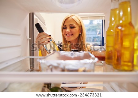 Woman Looking Inside Fridge Full Of Unhealthy Food