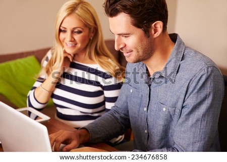 Couple Sitting At Computer In Home Office Shopping On Line