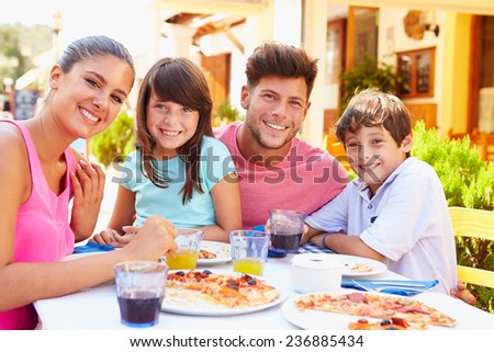 Portrait Of Family Eating Meal At Outdoor Restaurant