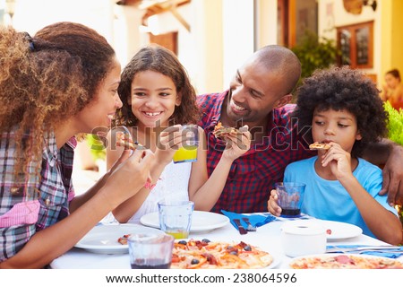 Family Eating Meal At Outdoor Restaurant Together
