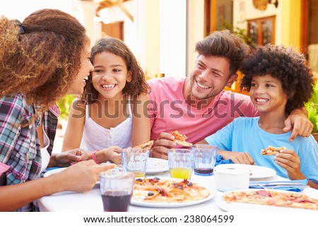 Family Eating Meal At Outdoor Restaurant Together