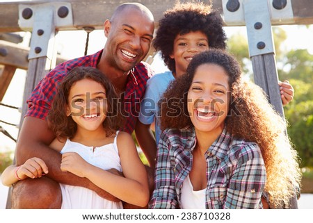 Portrait Of Family On Playground Climbing Frame