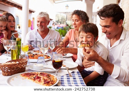 Multi Generation Family Eating Meal At Outdoor Restaurant
