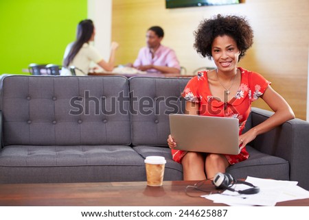 Woman Taking A Break Working On Sofa In Design Studio