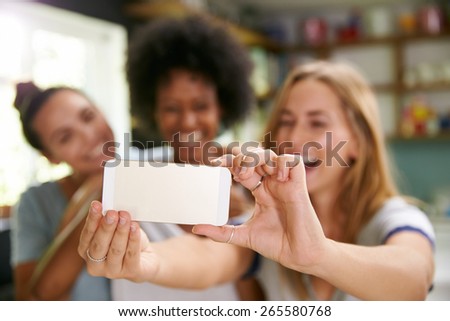 Three Female Friends Taking Selfie In Kitchen