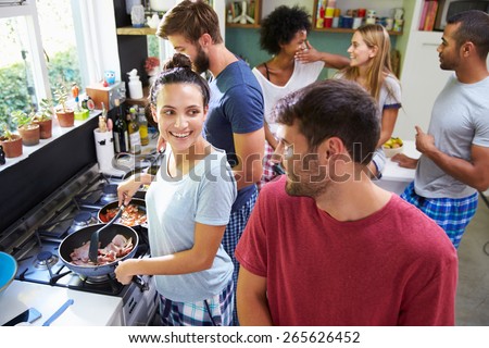 Group Of Friends Cooking Breakfast In Kitchen Together