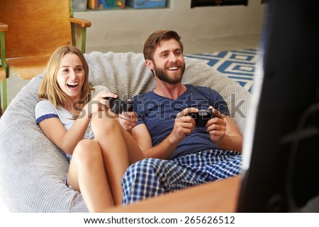 Young Couple In Pajamas Playing Video Game Together