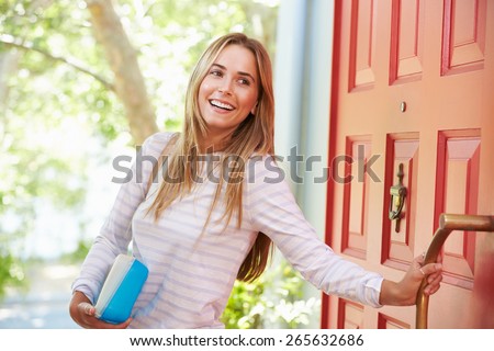 Young Woman Leaving Home For Work With Packed Lunch