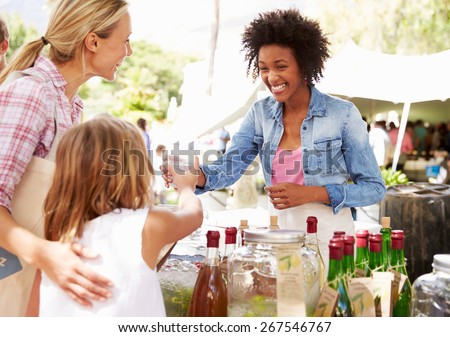 Woman Selling Soft Drinks At Farmers Market Stall