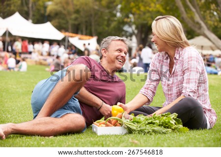 Couple With Fresh Produce Bought At Outdoor Farmers Market