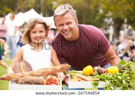 Father And Daughter With Produce From Outdoor Farmers Market