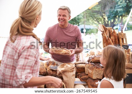 Family Buying Bread From Bakery Stall At Farmers Market
