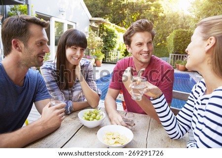 Group Of Friends Enjoying Outdoor Drinks In Garden