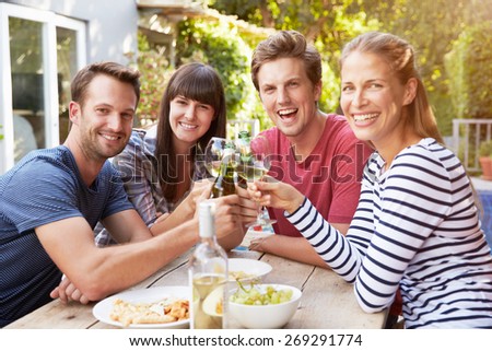 Group Of Friends Enjoying Outdoor Drinks In Garden