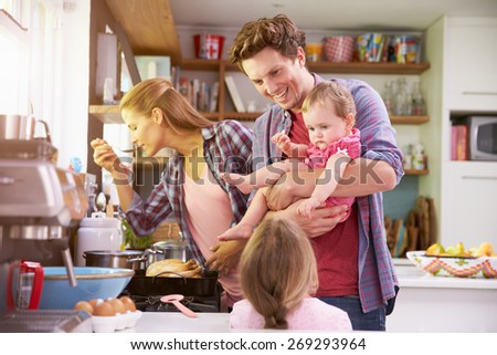 Family Cooking Meal In Kitchen Together