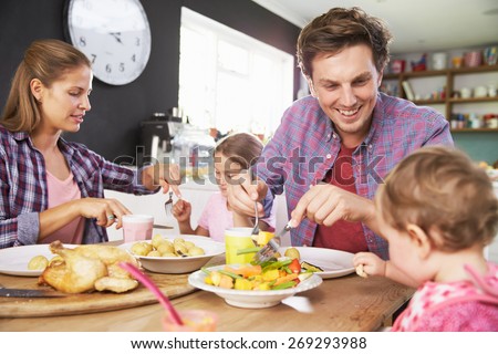 Family Eating Meal In Kitchen Together