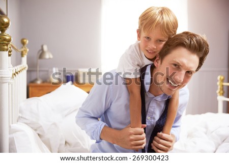 Son Hugging Father As He Gets Dressed For Work
