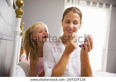 Daughter Watching Working Mother Put On Make Up