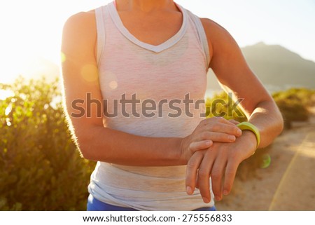 Young woman checking time on her sports watch