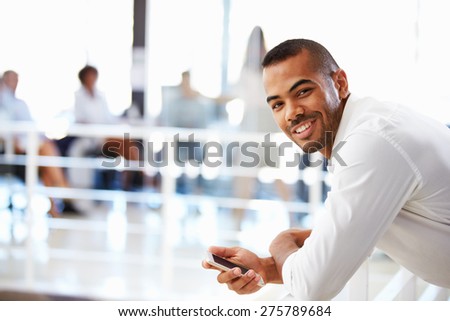 Portrait of man in office with telephone, smiling