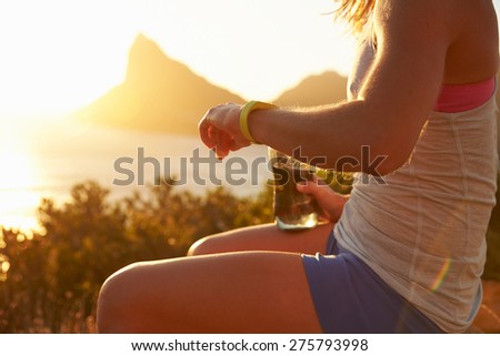 Young woman checking her sports watch